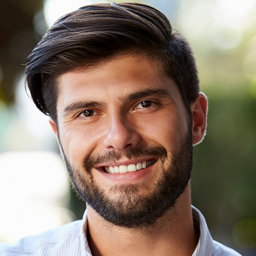 bearded-young-man-with-laptop-sitting-outside-cafe